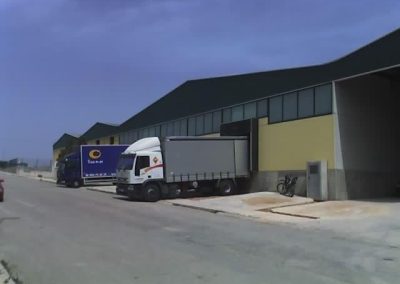 vista lateral del exterior de la fábrica de Mobles Albero con camiones cargando